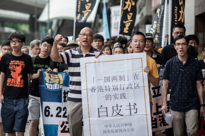 图片：2014年6月11日，香港的示威者们在中联办前集会，抗议中国国务院早前发布的《一国两制在香港特别行政区的实践》白皮书。（法新社）