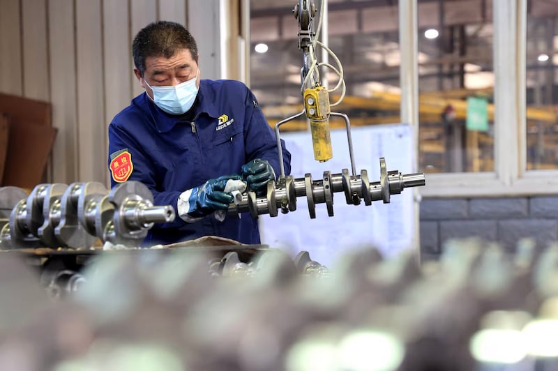 A quality inspector checks a crankshaft at a factory that produces mechanical parts for the domestic and export markets in Binzhou, Shandong province, Dec. 10, 2024.