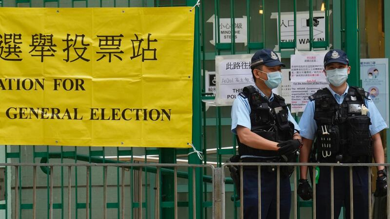 2021年香港立法会选举前，全副武装的警察在投票站附近站岗。（美联社）