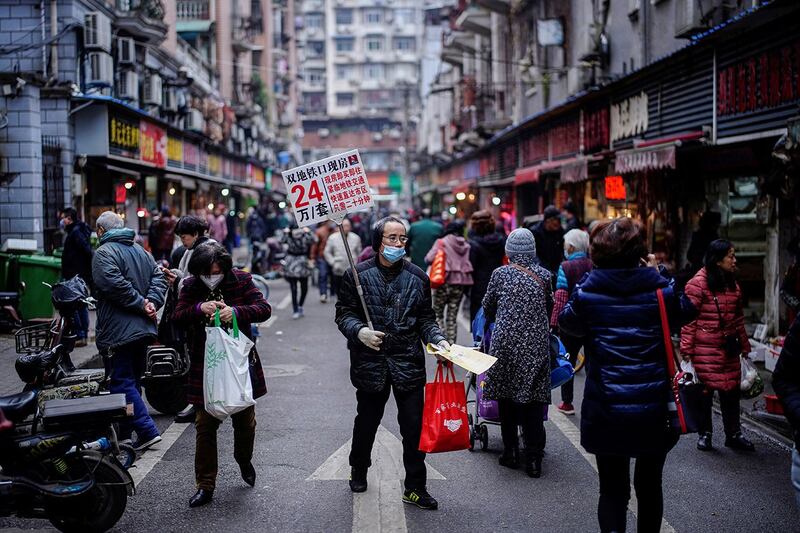 2020年12月7日，湖北省武汉市，新冠病毒爆发近一年后，一名男子在街上推销房子。（路透社）