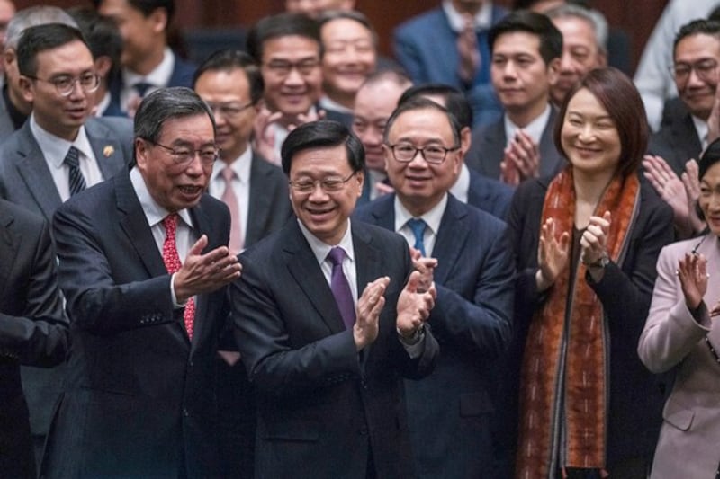 Hong Kong's Chief Executive John Lee (C) applauds with lawmakers following the passing of Article 23 legislation at the Legislative Council in Hong Kong on March 19, 2024. (Louise Delmotte/AP)