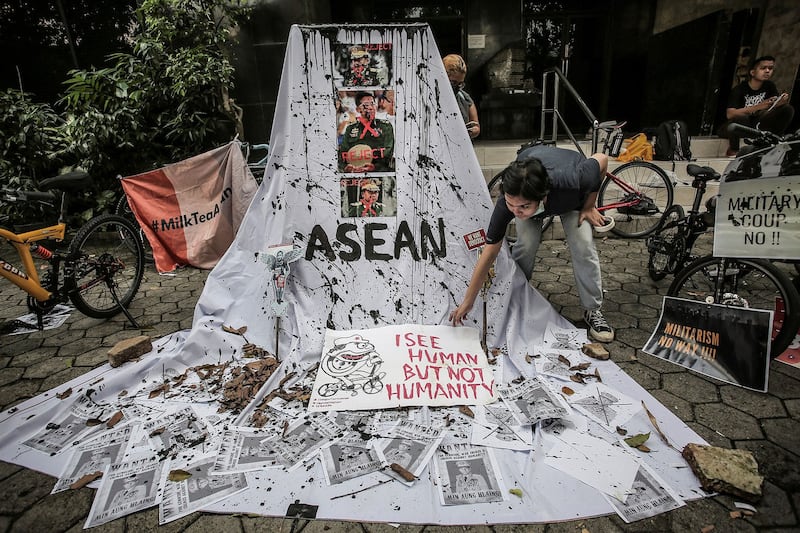 A woman sets a protest display with defaced pictures of Myanmar's junta leader Min Aung Hlaing in Jakarta, April 24, 2021. (Antara Foto/Dhemas Reviyanto via Reuters)