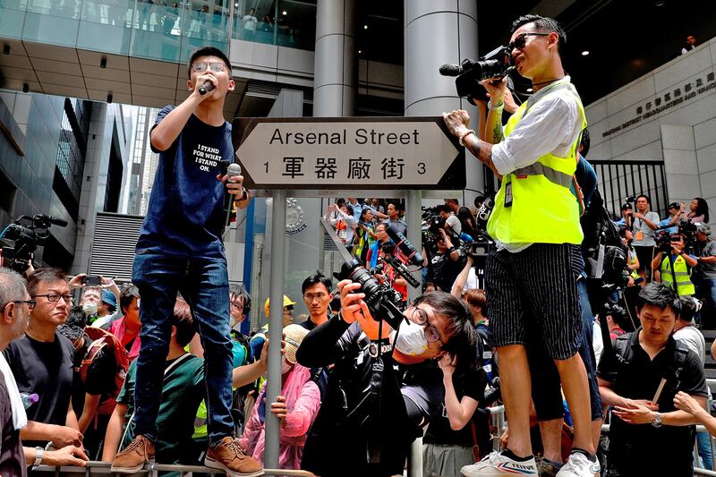 Photographers document pro-democracy activist Joshua Wong, left, as he speaks at the police headquarters in Hong Kong, June 21, 2019.