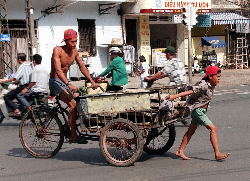 Một bé trai lao động cùng cha tại thành phố Hồ Chí Minh.  