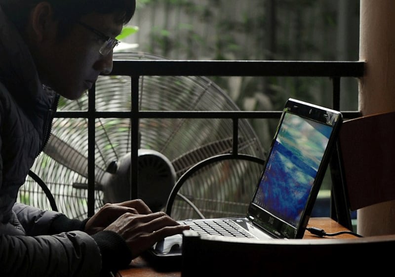 A man uses a laptop at a coffee shop in downtown Hanoi, Nov. 28, 2013. Vietnam has come under fire for various human rights abuses, including a crackdown on online dissent. 