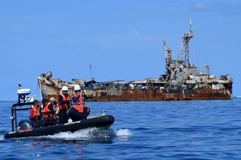 Philippine coast guard personnel and journalists sail on a rigid inflatable boat (L) as they head back after filming the BRP Sierra Madre, anchored at Second Thomas Shoal in disputed waters of the South China Sea, Nov. 10, 2023. (Jam Sta Rosa/AFP)