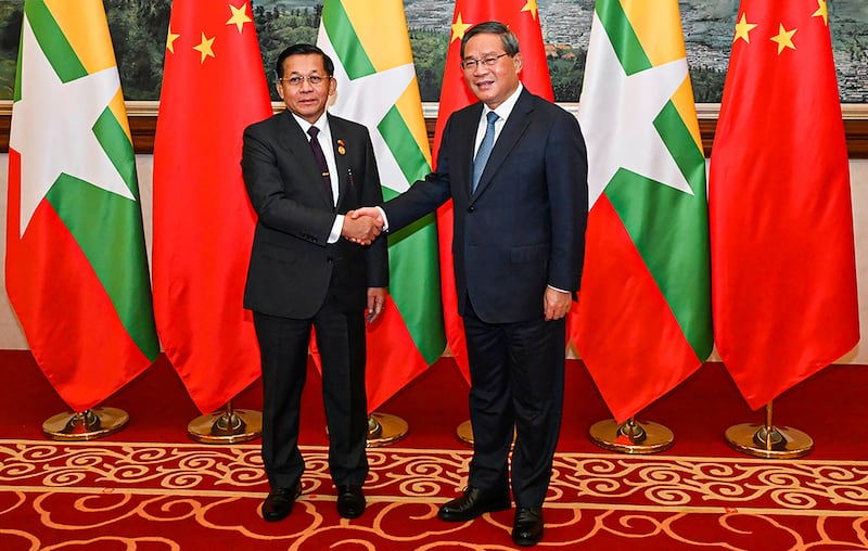 This photo taken on Nov. 6, 2024 and released by the Myanmar Military Information team shows Myanmar's military chief Min Aung Hlaing (L) shaking hands with China's Primier Li Qiang (R) ahead of a dinner reception during the Greater Mekong Subregion (GMS) Summit in Kunming, southern China's Yunnan Province . (AFP PHOTO / MYANMAR MILITARY INFORMATION TEAM)