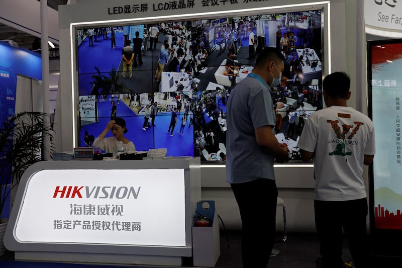 A staff member sits in front of a screen displaying footage from surveillance cameras, at the Hikvision booth at Security China, the China International Exhibition on Public Safety and Security, in Beijing, June 7, 2023. Credit: Florence Lo/Reuters