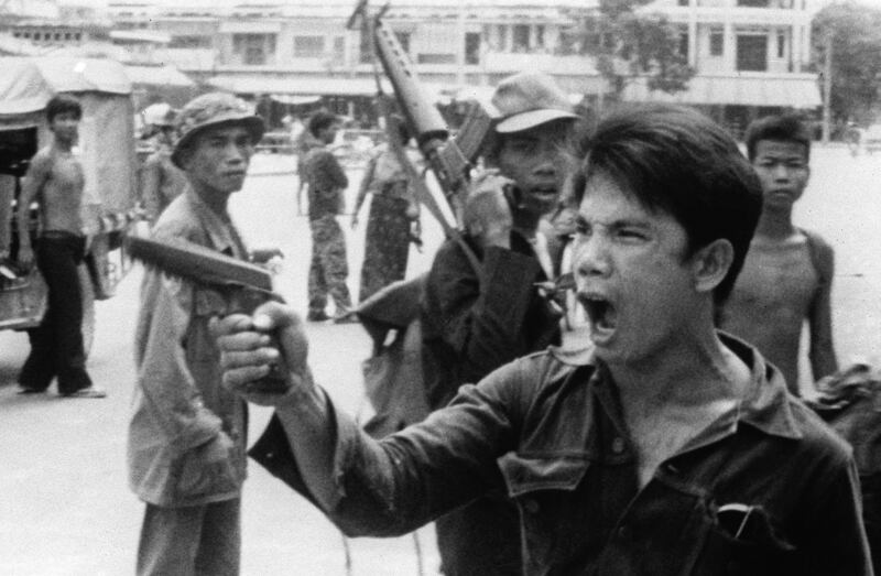 A MONATIO soldier waves his pistol and orders store owners to abandon their shops in Phnom Penh, Cambodia, on April 17, 1975, as the capital falls to the communist forces. Credit: Associated Press