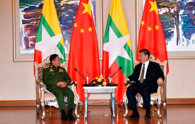 Myanmar's Army Commander Senior Gen. Min Aung Hlaing, left, speaks with Chinese President Xi Jinping at a hotel in Naypyidaw