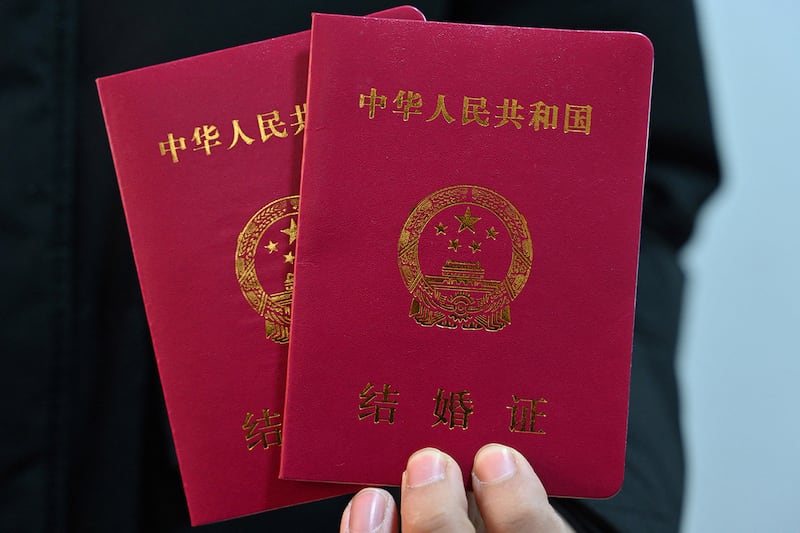 A newlywed man shows marriage books for him and his wife in Luliang, northern China's Shanxi province on Feb.11, 2025.