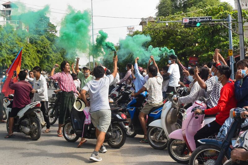 This photo taken and received courtesy of an anonymous source via Facebook shows protesters, some holding flares, taking part in a demonstration against the military coup in Monywa, Sagaing Region, June 21, 2021. HANDOUT / FACEBOOK / AFP