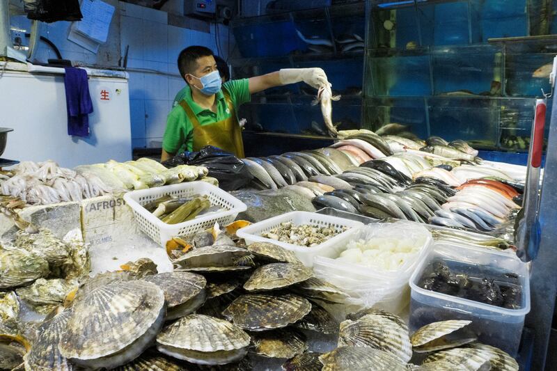 A man works at a fish and seafood stall at a wet market in Beijing, China, Aug. 14, 2020. Credit: Reuters