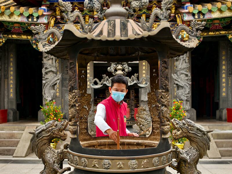 A man places incense sticks at the Taishan Up Temple, a Taoist temple built in 1754, New Taipei City, Taiwan, March 2, 2023.