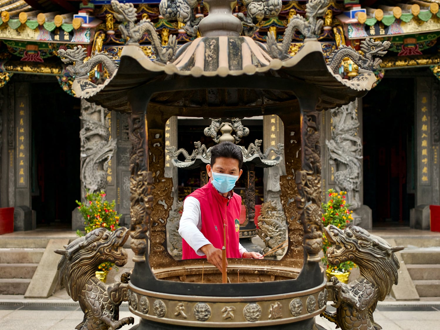 A man places incense sticks at the Taishan Up Temple, a Taoist temple built in 1754, New Taipei City, Taiwan, March 2, 2023.