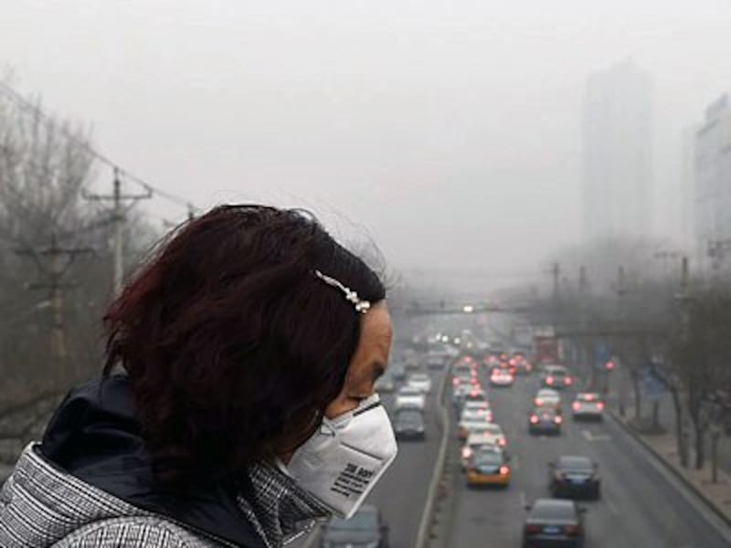 A Chinese woman wears a face mask on a heavily polluted day in Beijing, Dec. 26, 2015.