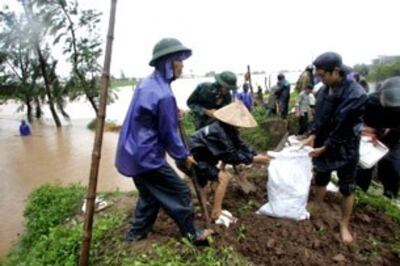 Dân chúng đang đắp lại phần đê bị phá vỡ (ảnh minh họa). AFP PHOTO