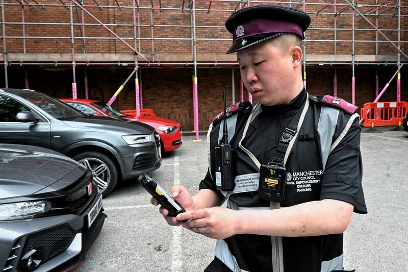 梁銘康年初移居英國曼徹斯特後，放下拿了六年多的相機，轉而穿起制服、拿起對講機，成為一名交通督導員，專責向違例泊車者發告票。（梁銘康提供）