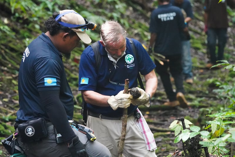 Roger Hess, right, and a member of the Norwegian People’s Aid clearance team inspect an abandoned WWII munition on Umurbrogal Mountain in Peleliu, Palau, Nov. 26, 2024.