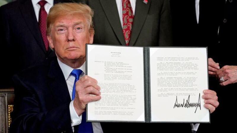 US President Donald Trump holds his signed memorandum on intellectual property tariffs on high-tech goods from China, at the White House in Washington, March 22, 2018.