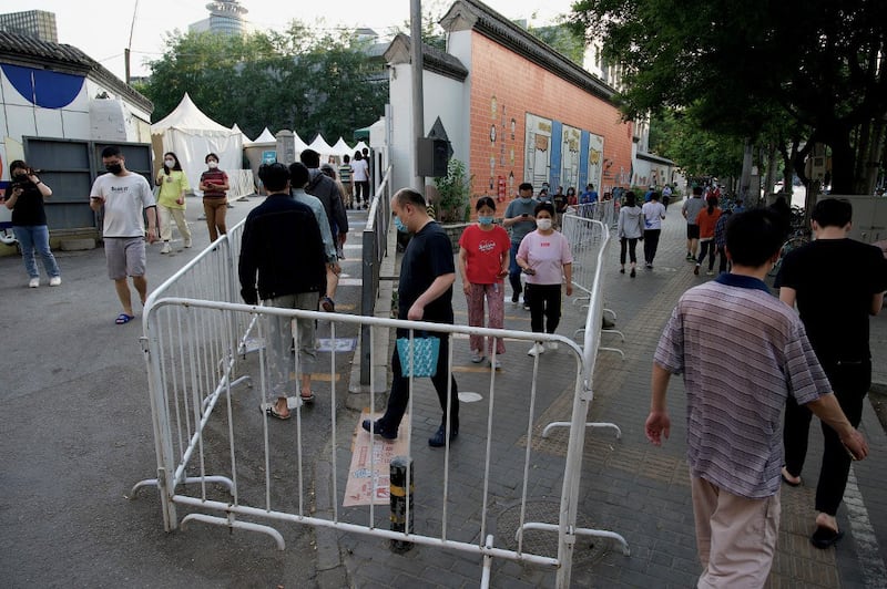 People queue for swab to be tested for Covid-19 coronavirus at a swab collection site in Beijing on May 18, 2022. Credit: AFP