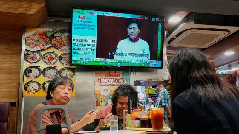 2021 年 10 月 6 日，在香港一家餐厅，电视屏幕显示香港行政长官林郑月娥举行的新闻发布会上讲话。 （美联社）