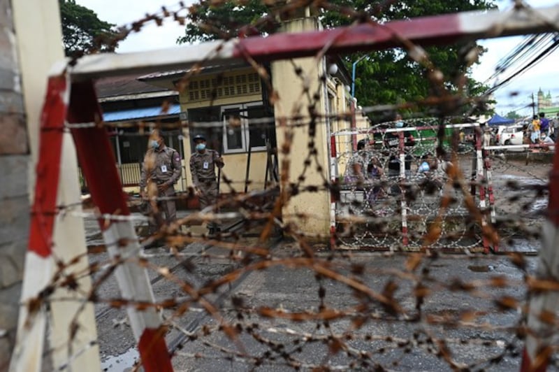 Police are seen behind barbed wire outside Insein Prison in Yangon, Myanmar, Oct. 18, 2021. (AFP)