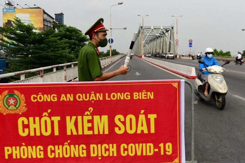 Ảnh minh họa: Một công an đứng gác tại một chốt kiểm soát ở Hà Nội vào ngày 29 tháng 7 năm 2021.