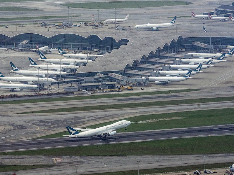 Passenger airplanes are seen parked on the tarmac as a Cathay Pacific Cargo plane takes off at Hong Kong’s Chek Lap Kok International Airport, Hong Kong, April 24, 2020.