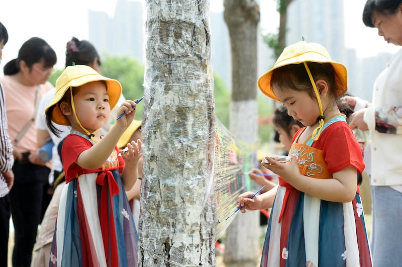 Children paint on a plastic sheet at a park on International Children's Day in Haian, China's eastern Jiangsu province on June 1, 2022. Credit: AFP