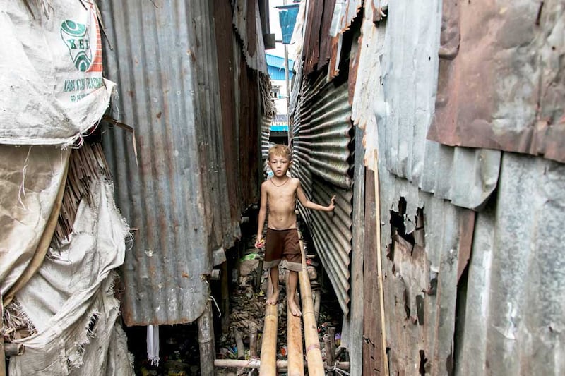 A boy walks on a bamboo bridge near his home on the outskirts of Yangon. (AFP)