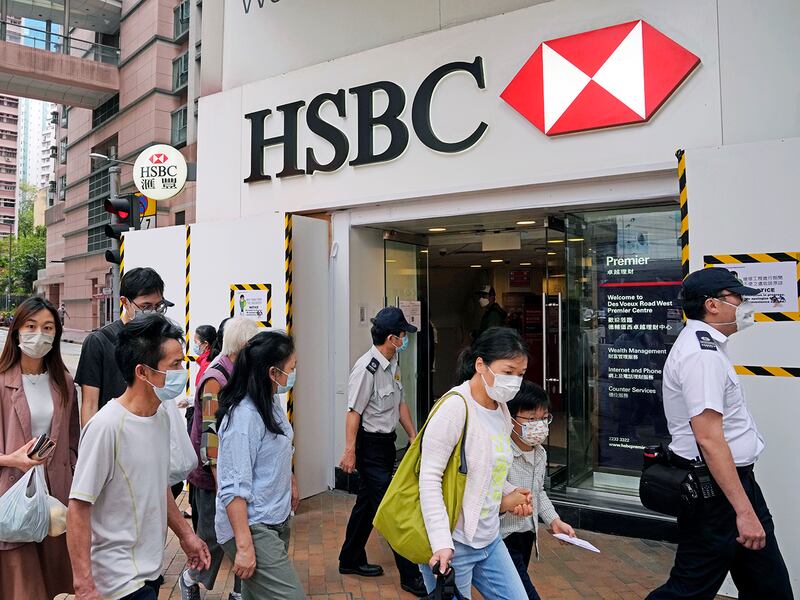 People walk past a branch of HSBC bank in Hong Kong, March 16, 2022.