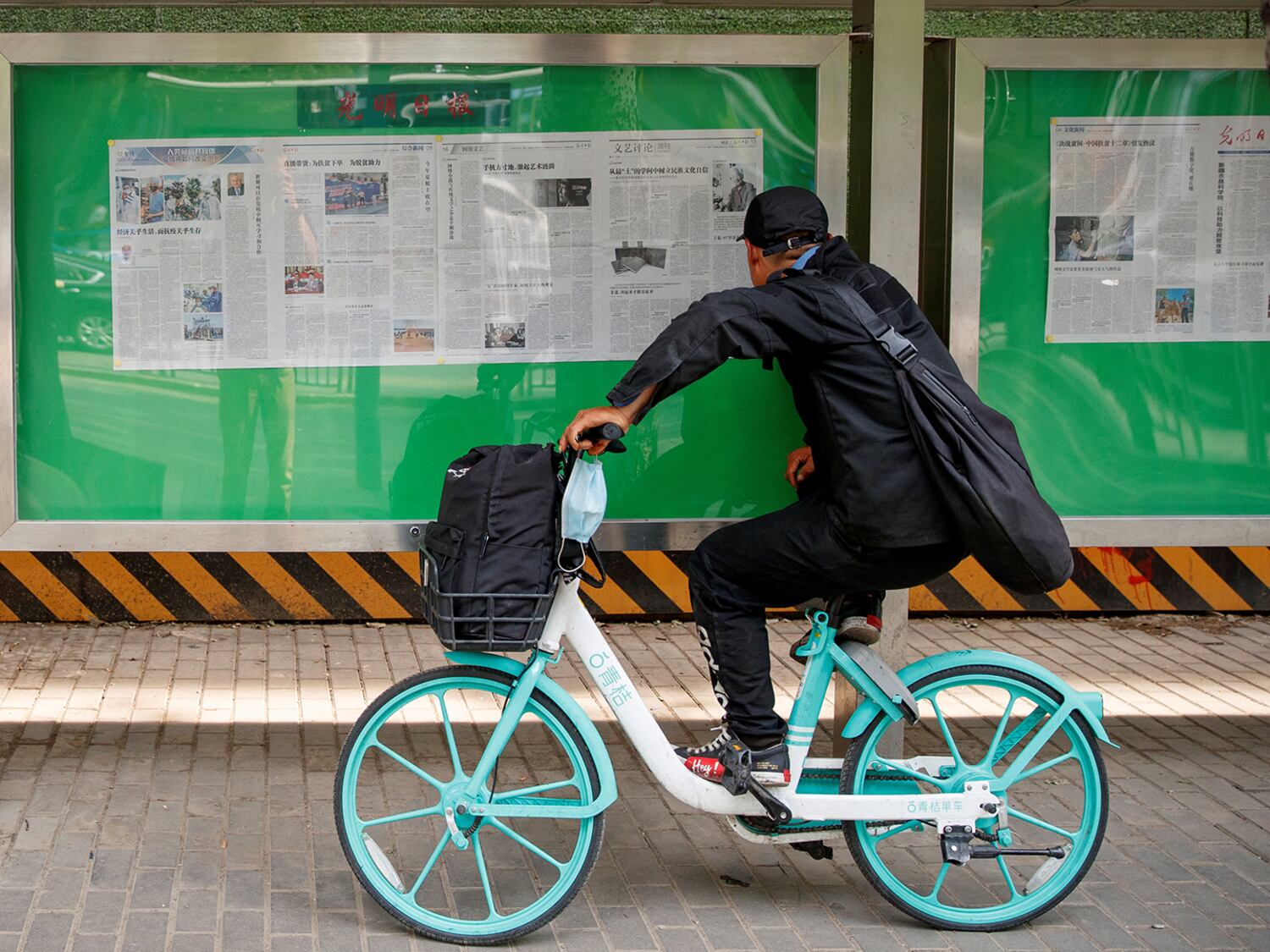 A man reads an issue of the Guangming Daily newspaper at a public display window in Beijing, China,  June 10, 2020.