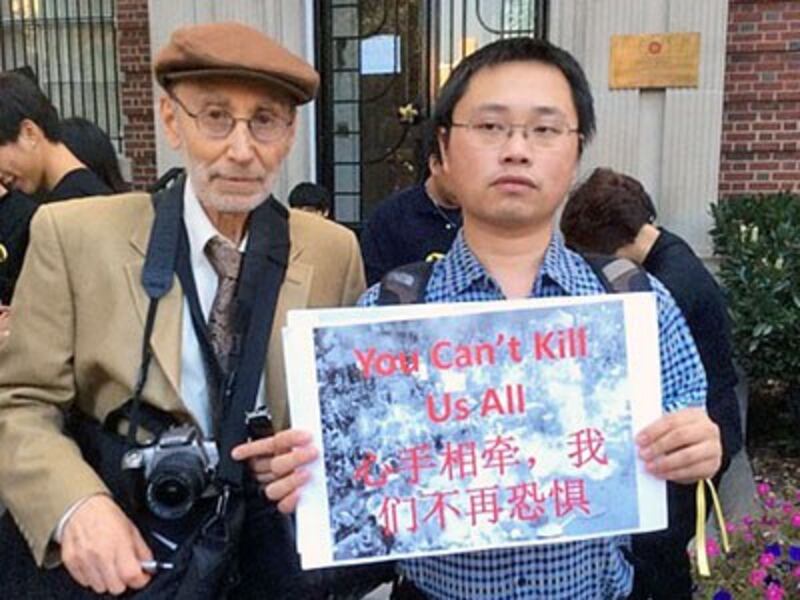 Gu Yi (R), a student at the University of Georgia in the United States, holds a poster reading, 'You can't kill us all,' in response to China's increased oppression of dissidents, in an undated photo.