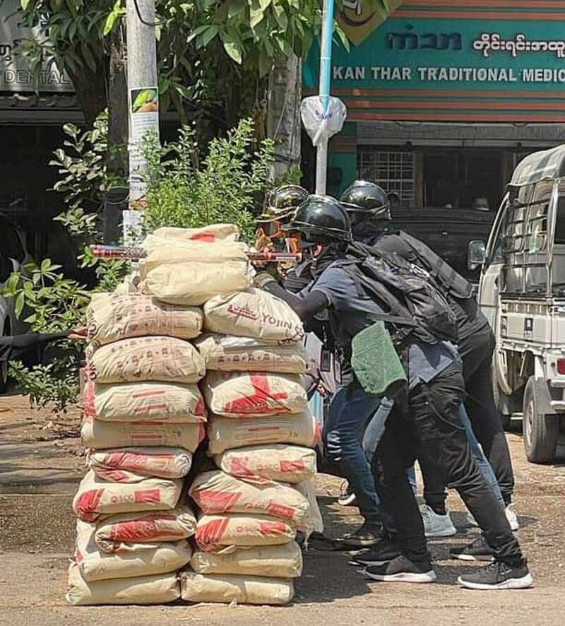 Protesters take aim with fireworks while manning a barricade in Yangon on Thursday. Photo courtesy of a citizen journalist