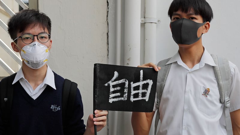 2019年9月6日，香港一所学校外学生们形成一条人体链，手持“自由”标语牌。（美联社）