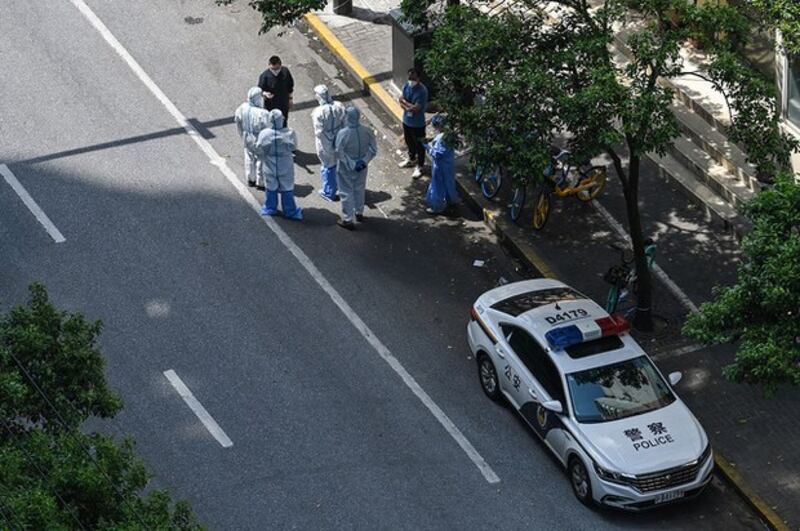 身穿防护服装的警车停在上海静安区街道上。（AFP）