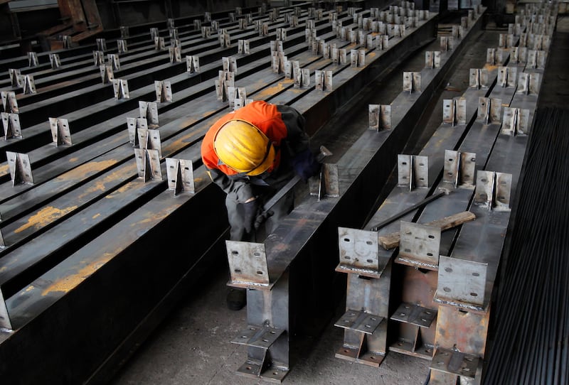 A man polishes steel beams at a steel factory in Que Vo district, outside Hanoi May 20, 2011.  Vietnam's economy could grow 5.3 percent this year with annual inflation of 16.9 percent, the Vietnam Central Institute for Economic Management forecasted. REUTERS/Kham (VIETNAM - Tags: BUSINESS EMPLOYMENT)