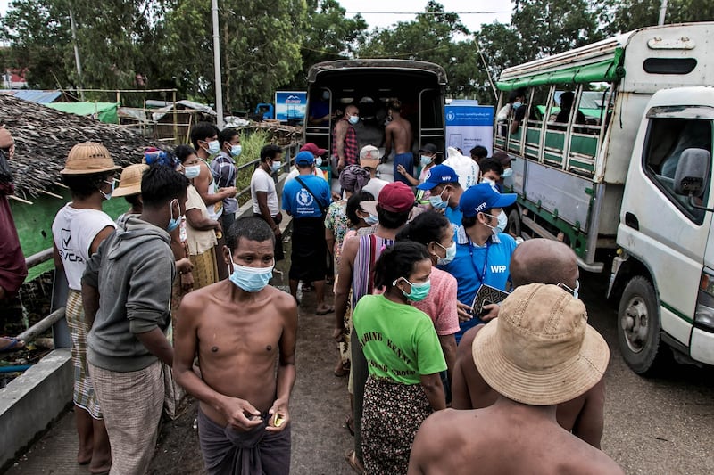 Residents of an improvised neighborhood gather to receive rice distributed by the World Food on the outskirts of Yangon, May 21, 2021. Over half the population in Myanmar live beneath the poverty line. (AFP Photo)