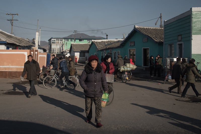 People cross a street on the outskirts of the industrial city of Chongjin on North Korea's northeast coast on November 21, 2017. (AFP Photo/Ed Jones)