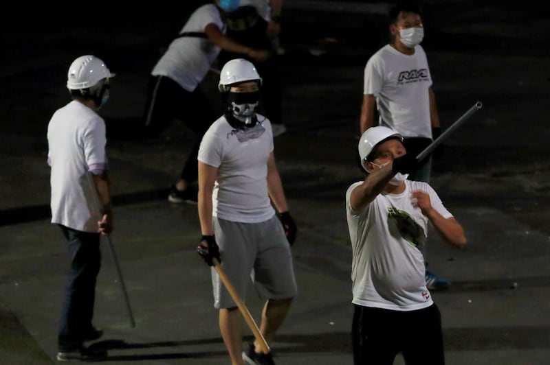 Men in white T-shirts with poles are seen in Yuen Long after attacking anti-extradition bill demonstrators at a train station in Hong Kong, July 22, 2019. Credit: Reuters