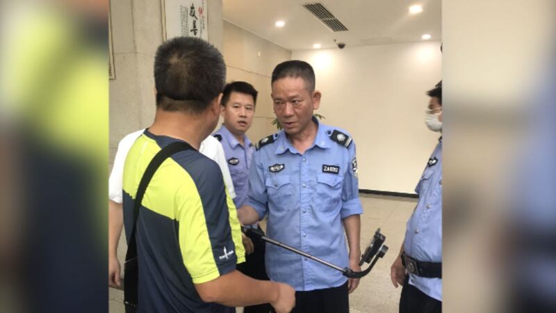 2020年9月11日，长沙中院法警阻止谢阳拍摄。（施明磊推特）