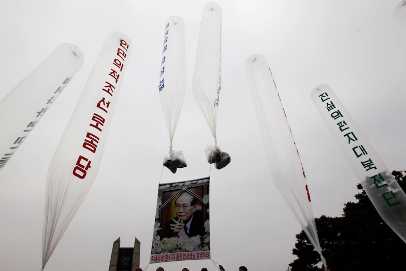 A portrait of deceased North Korean defector Hwang Jang Yop is hung on balloons as former North Korean defectors and anti-North Korean activists prepare to release them towards the North, near the demilitarized zone separating the two Koreas in Paju, north of Seoul, Oct. 10, 2011.