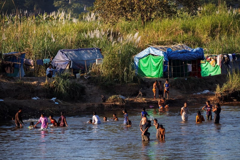 Refugees, who have fled a flare-up in fighting between the Myanmar army and insurgent groups and settled temporarily on the Moei River Bank, bathe in the river waters on the Thai-Myanmar border, in Mae Sot, Thailand, Jan. 7, 2022. REUTERS/Athit Perawongmetha