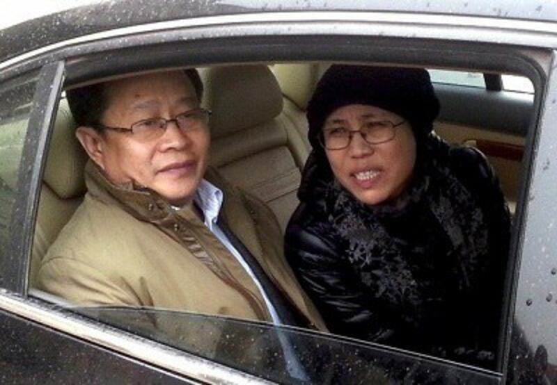 Liu Xia (r) and rights lawyer Mo Shaoping (l) arrive at court for her brother's trial in Beijing, April 23, 2013. Photo credit: AFP.