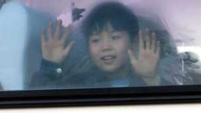 A young North Korean defector waves from a bus on its way to Seoul, Mar. 18, 2002.