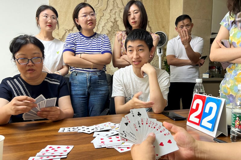 Finance professionals learn how to play Guandan, a poker-like card game, during a training session in Beijing, China Aug. 6, 2023. (Yew Lun Tian/Reuters)