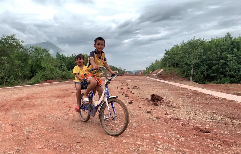 Children cycling on an embankment of the China-Lao railway under construction near their village in Hin Heub district, Vientiane province.