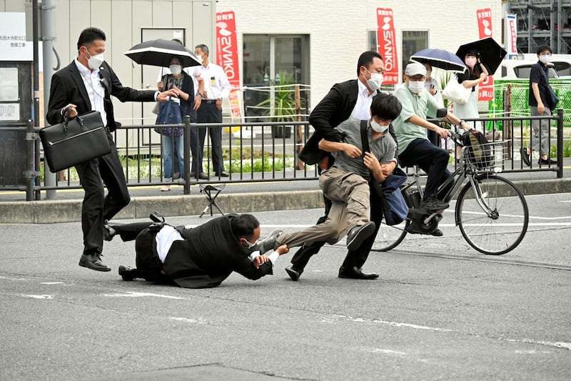 A man who is believed to have shot former Japanese Prime Minister Shinzo Abe is tackled by police in Nara, Japan, on July 8, 2022. (The Asahi Shimbun via Reuters)