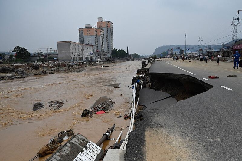 2021 年 7 月 22 日，河南省郑州市附近的县级巩义市遭遇洪水和山体滑坡后的道路坍塌。 （美联社）